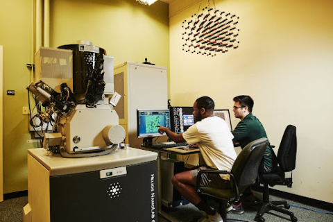 Two people working on computers in the Helios NanoLab 650 