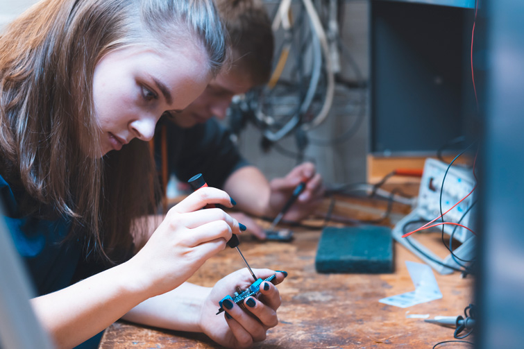 Female computer engineering student working on a small computer panel