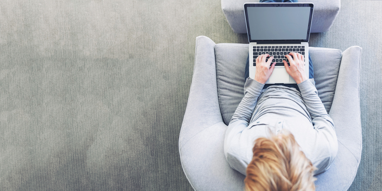 student sitting on couch working on laptop